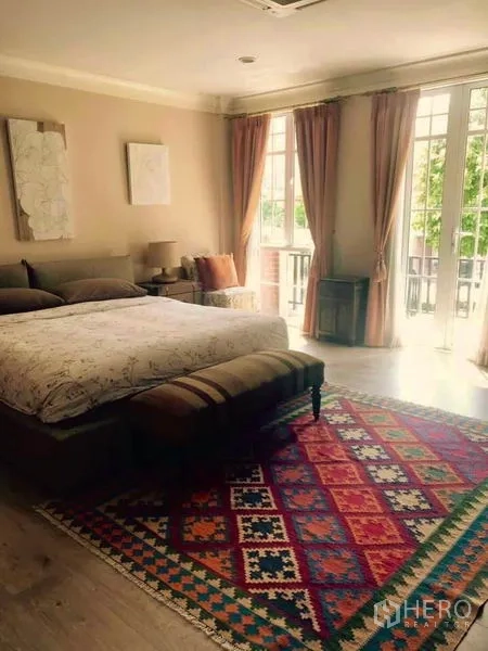 ทาวน์เฮาส์ ให้เช่าหรือขายในBangkok - ห้องนอนใหญ่โปร่งสบาย มีหน้าต่างบานใหญ่ ประตูออกระเบียง และพรมลายสวย