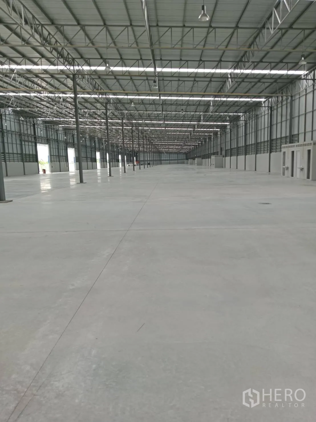 仓库 for rent in Lat Krabang, Bangkok - 长通道式仓库，混凝土地坪，成排立柱与吊装工业照明。