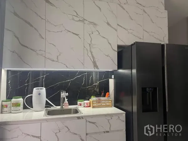 独立式住宅 出售在Bueng Kum, Bangkok - 现代厨房，石纹橱柜与黑色石材挡板，水槽及对开门冰箱。