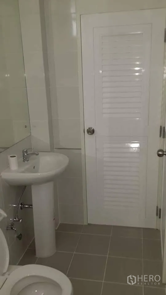 คอนโด ให้เช่าในPathum Wan, Bangkok - ห้องน้ำสะอาด มีอ่างล้างหน้าตั้งพื้น โถสุขภัณฑ์ กระจกเงา และประตูบานเกล็ดสีขาว