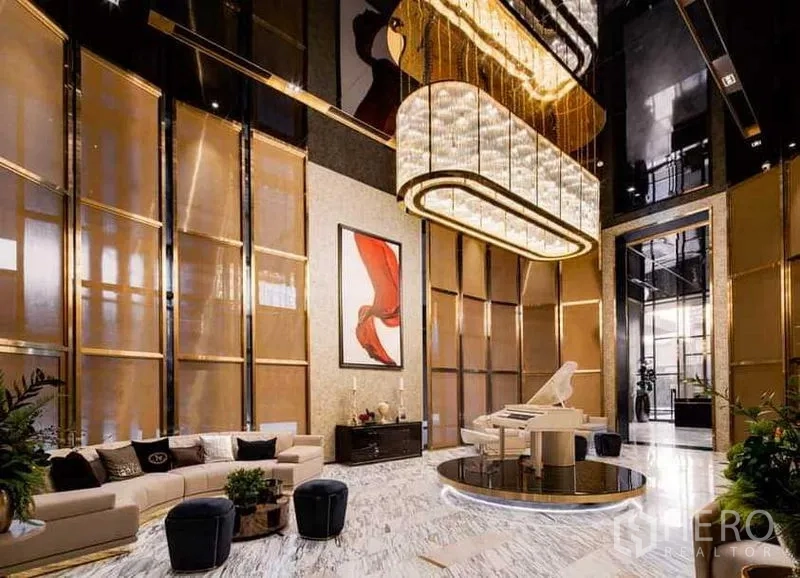 คอนโด ให้เช่า - ล็อบบี้คอนโดสุดหรู พื้นหินอ่อน โคมระย้าขนาดใหญ่ มุมที่นั่ง และเปียโนสีขาว