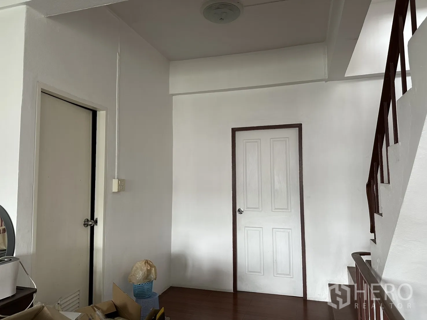 店屋 for rent in Phra Khanong, Bangkok - 楼上走廊，两个白色门与楼梯扶手。
