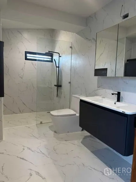 Detached House for rent in Suan Luang, Bangkok - Contemporary bathroom with glass shower, black fixtures and wide vanity.