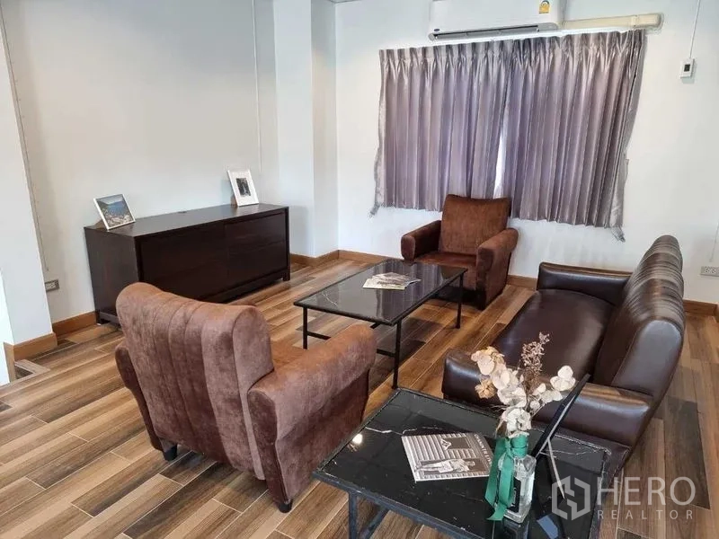 独立式住宅 出租在Mueang Nonthaburi, Nonthaburi - 舒适会客角，棕色沙发、黑色茶几和边柜，带空调。