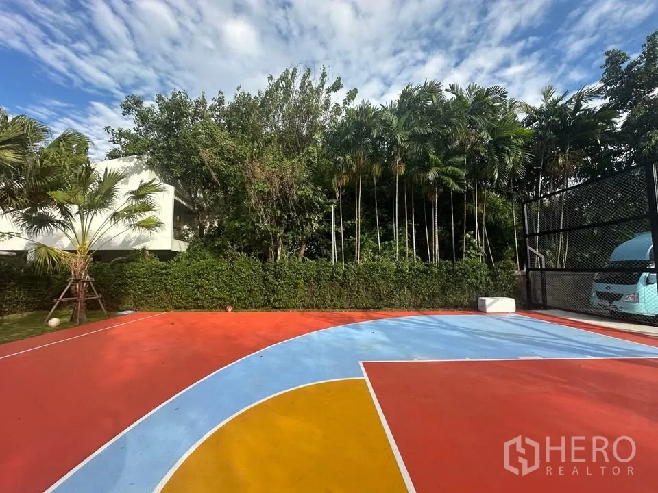 ที่ดิน for rent in Watthana, Bangkok - พื้นสนามสีสันสดใส รายล้อมด้วยแนวต้นไม้สูงและรั้วพุ่มไม้ ให้ความเป็นส่วนตัวบนแปลงที่ดินสุขุมวิท