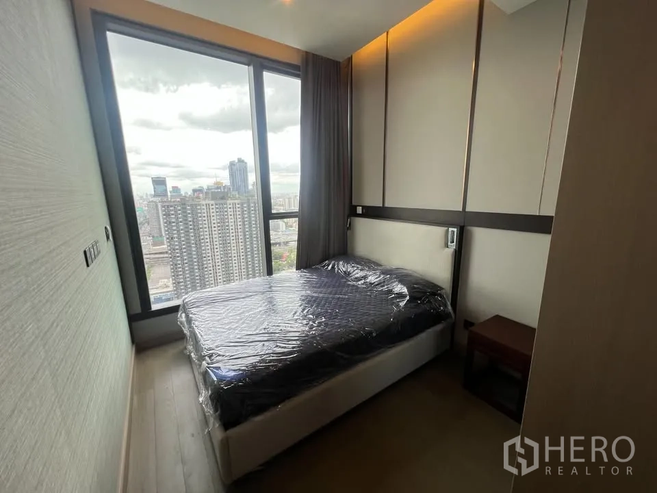 公寓 出租在Huai Khwang, Bangkok - 卧室设软包床头与氛围灯，大窗展示城市景色。