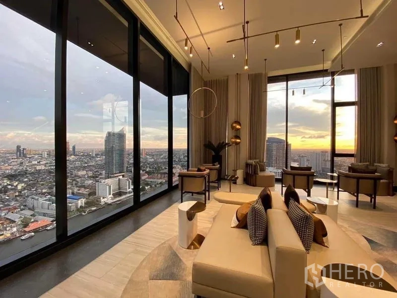 คอนโด ให้เช่าในKhlong San, Bangkok - ห้องนั่งเล่นชั้นสูงผนังกระจกเต็มบาน เห็นพระอาทิตย์ตกและวิวแม่น้ำเจ้าพระยา