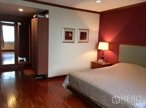 คอนโด ให้เช่าหรือขายในWatthana, Bangkok - ห้องนอนหลักพื้นไม้ ผนังแต่งสี และโคมไฟหัวเตียง