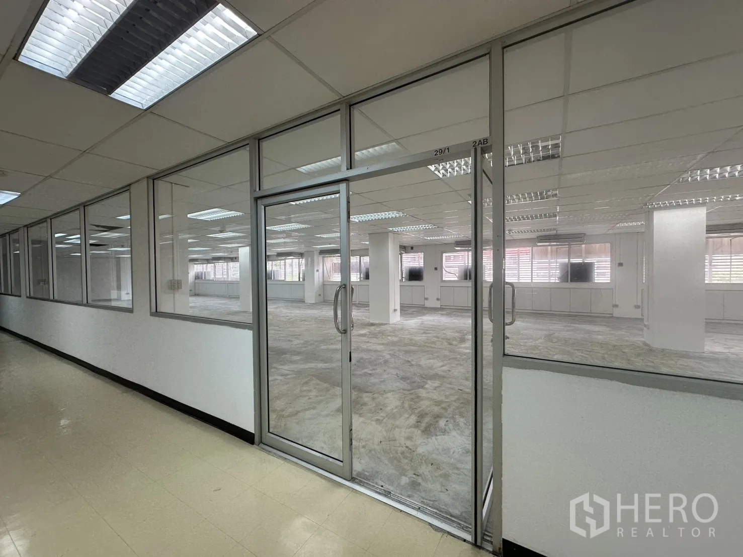 ออฟฟิศ for rent in Pathum Wan, Bangkok - มุมมองจากโถงทางเดินเห็นผนังกระจกเต็มสูงและประตูกระจกคู่ของสำนักงาน