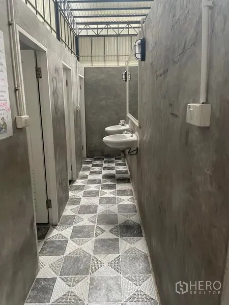 货栈 出租在Saphan Sung, Bangkok - 卫生间区域，挂墙式洗手盆、隔间与几何地砖，位于仓库内。