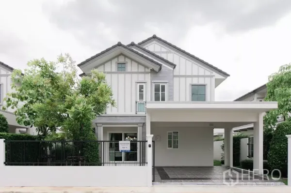 独立式住宅 出租或出售在Bang Phli, Samut Prakan - 现代白色两层独栋别墅正立面，带围栏与有顶车棚。