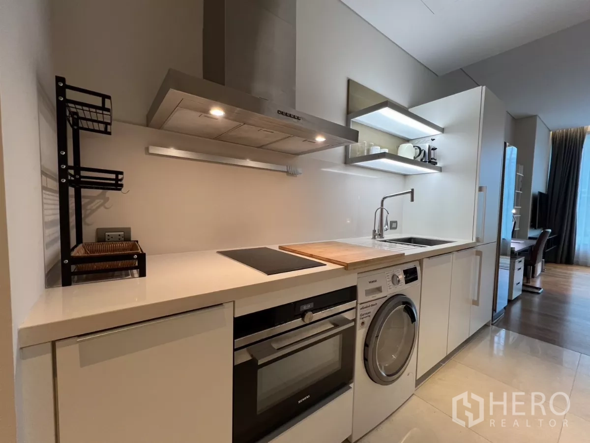 คอนโด ให้เช่าในPathum Wan, Bangkok - ครัวบิวต์อินสไตล์แกลลี พร้อมเตาไฟฟ้า เตาอบ และเครื่องซักอบในท็อปสีขาว