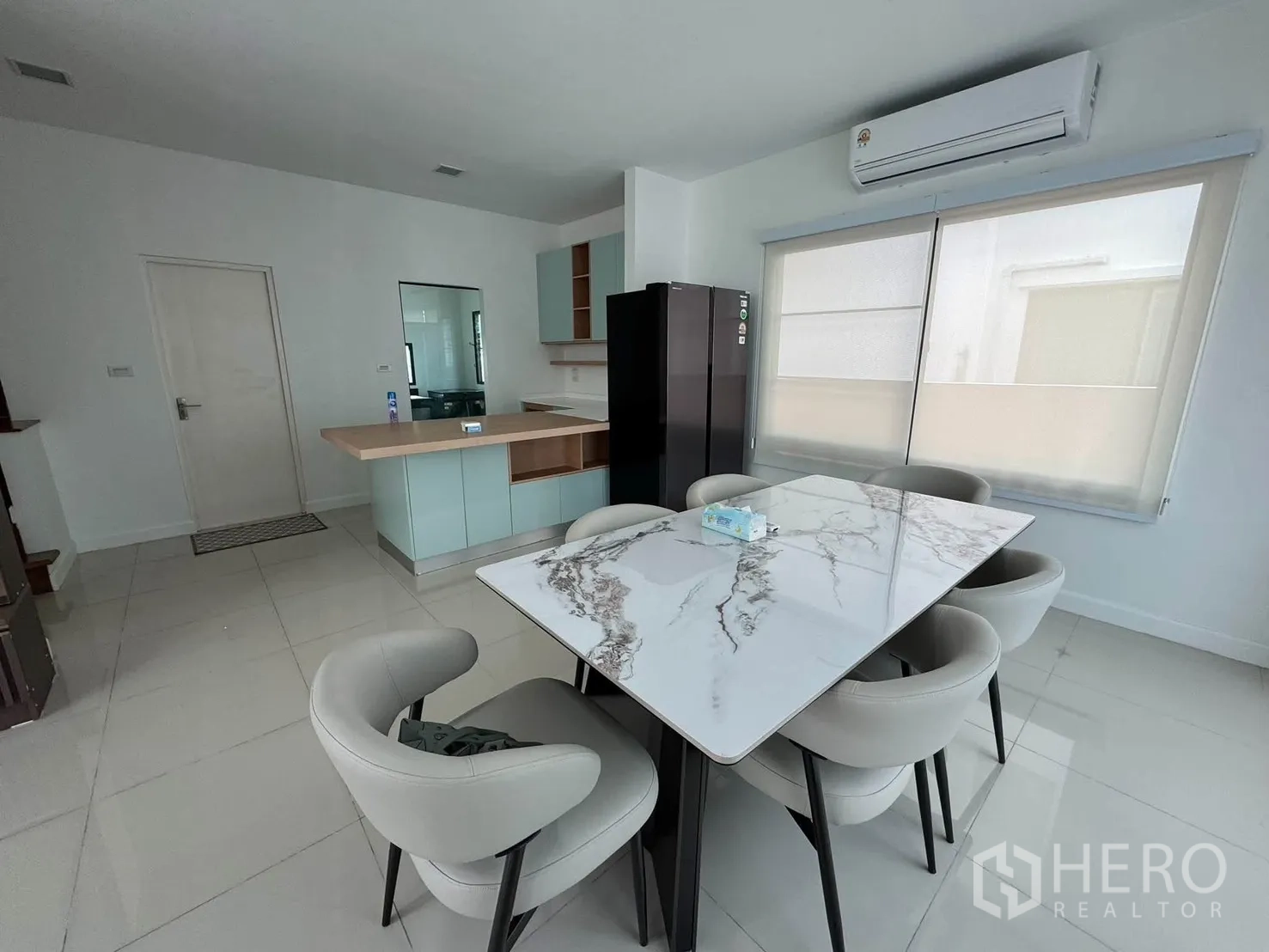 บ้านเดี่ยว for rent in Prawet, Bangkok - มุมทานอาหารโต๊ะหินอ่อน 6 ที่นั่ง ข้างหน้าต่างบานใหญ่และเครื่องปรับอากาศ