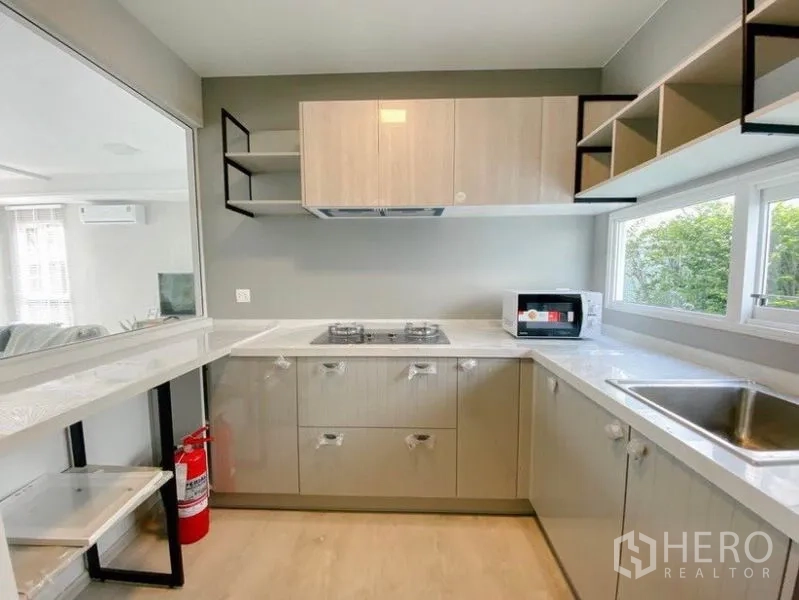 独立式住宅 出租在Prawet, Bangkok - U形现代厨房，燃气灶、储物柜与园景窗