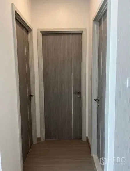 คอนโด ให้เช่าในBang Rak, Bangkok - โถงทางเดินพร้อมประตูไม้สามบาน เชื่อมไปยังห้องนอนและห้องน้ำของคอนโด