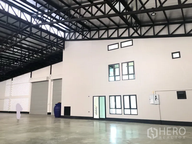 โรงงาน ขายในPathum Thani - มุมมองโกดังพร้อมอาคารสำนักงานหน้าต่างหลายบานและประตูม้วนขนาดใหญ่สองบาน