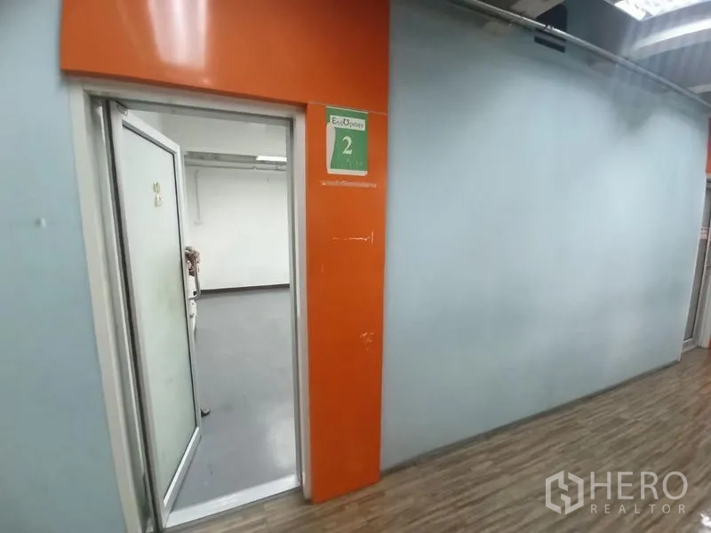 สำนักงาน ให้เช่าในRatchathewi, Bangkok - มุมมองทางเดินไปยังประตูห้องสำนักงานหมายเลข 2 กรอบสีส้มโดดเด่น.