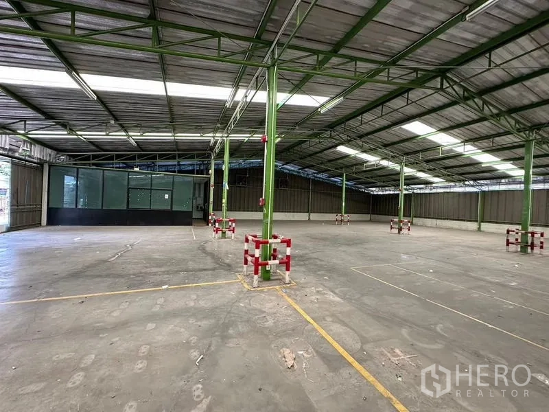 货栈 出租在Prawet, Bangkok - 仓库内部，绿色立柱与玻璃监控室