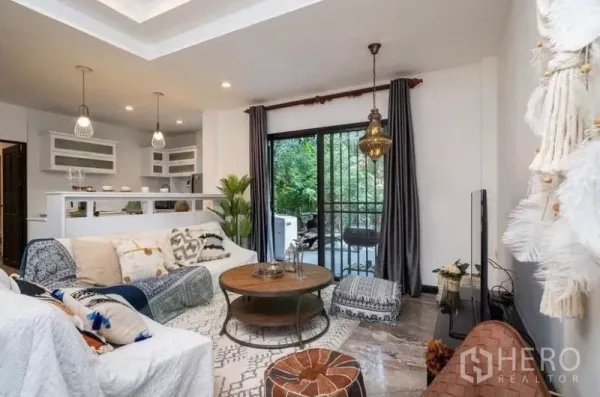 Detached House for rent in Ratchathewi, Bangkok - Living area opening via sliding doors to a balcony with garden view.