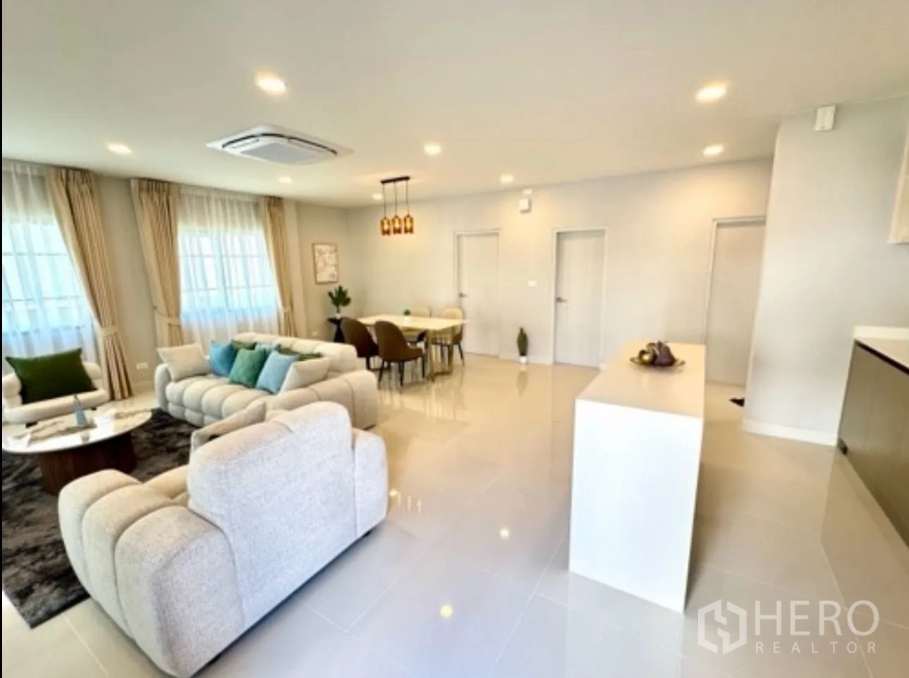 独栋房屋 for rent in Bang Phli, Samut Prakan - 明亮的开放式客餐厅，配沙发、餐桌和中岛台。