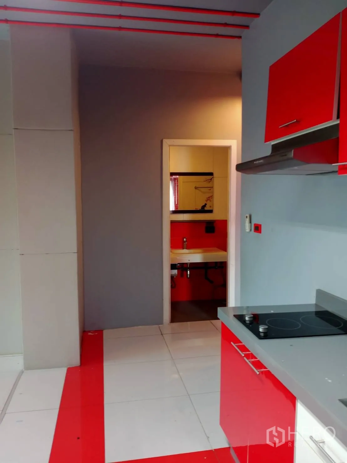 办公空间 出租在Khlong Toei, Bangkok - 紧凑茶水间，红色柜体、电磁炉，并通向独立卫浴。