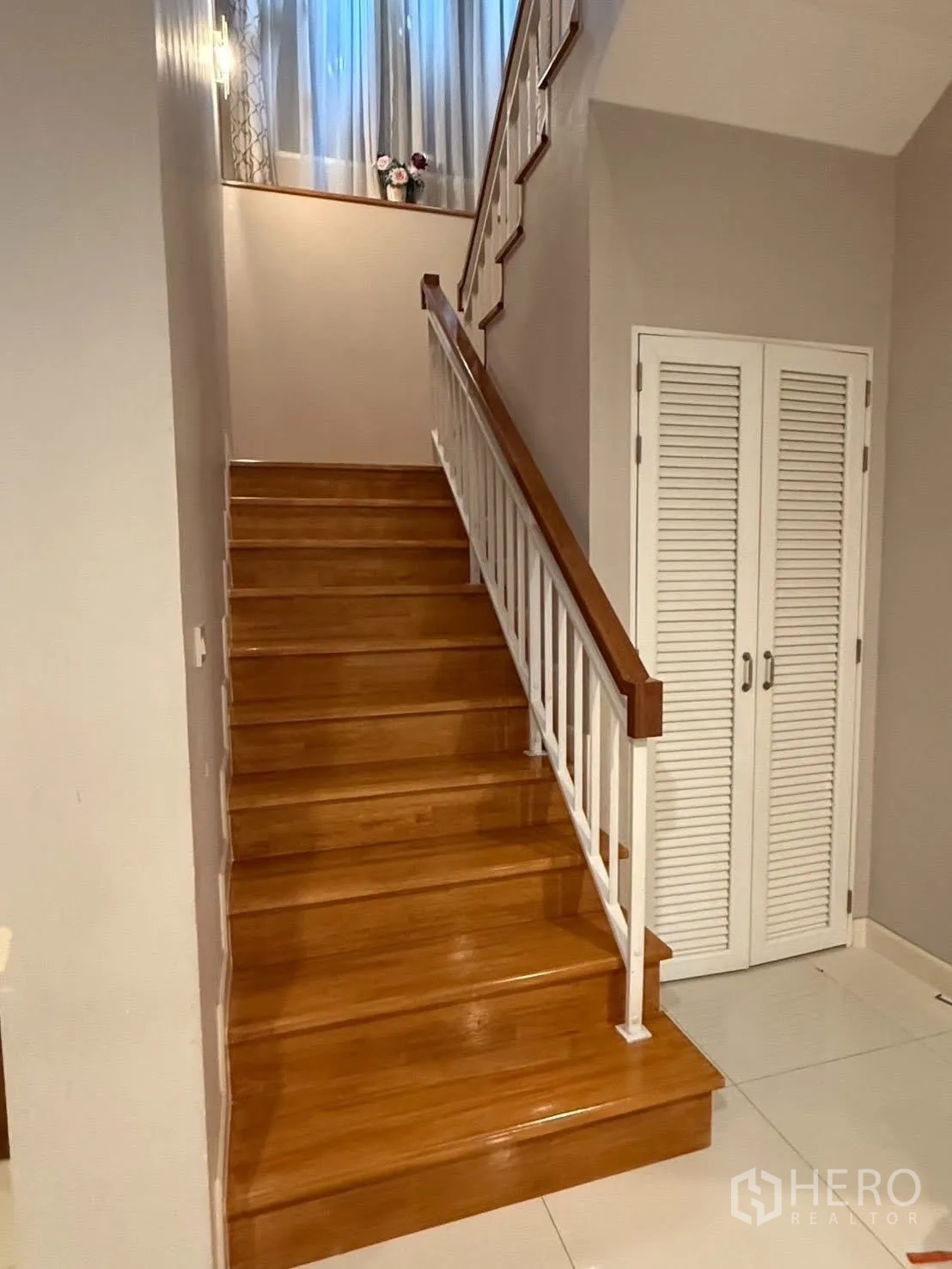 Detached House for rent in Bang Na, Bangkok - Polished wooden staircase with white railing leading to the upper floor.