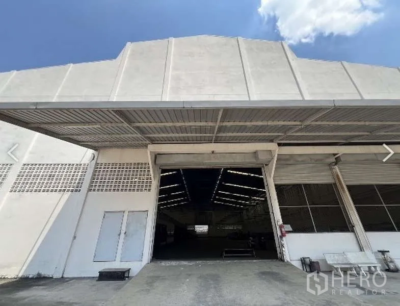 คลังสินค้า ให้เช่าในWatthana, Bangkok - ด้านหน้าโกดังเขตวัฒนา พร้อมประตูม้วนกว้างและลานโหลดสินค้ามีหลังคา