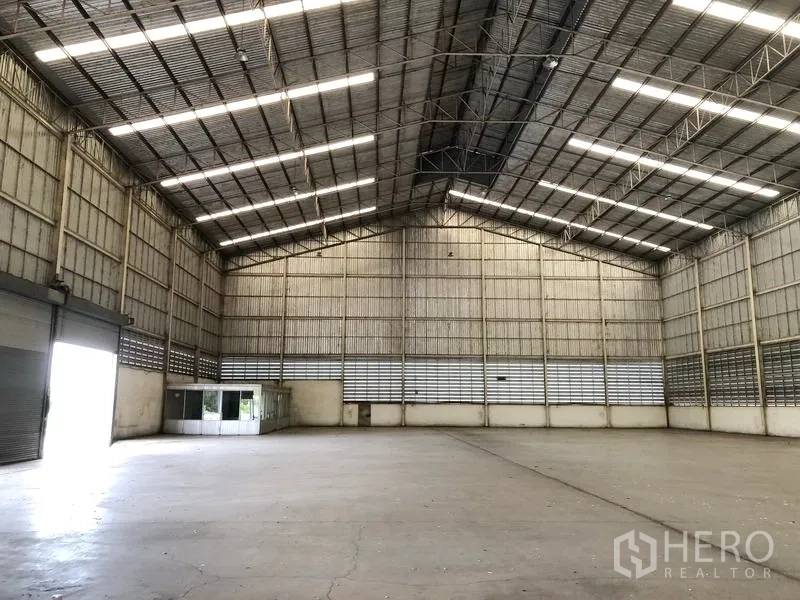 货栈 出租在Phra Nakhon Si Ayutthaya - 仓库内部设有大卷闸门与角落玻璃办公室，层高通透。