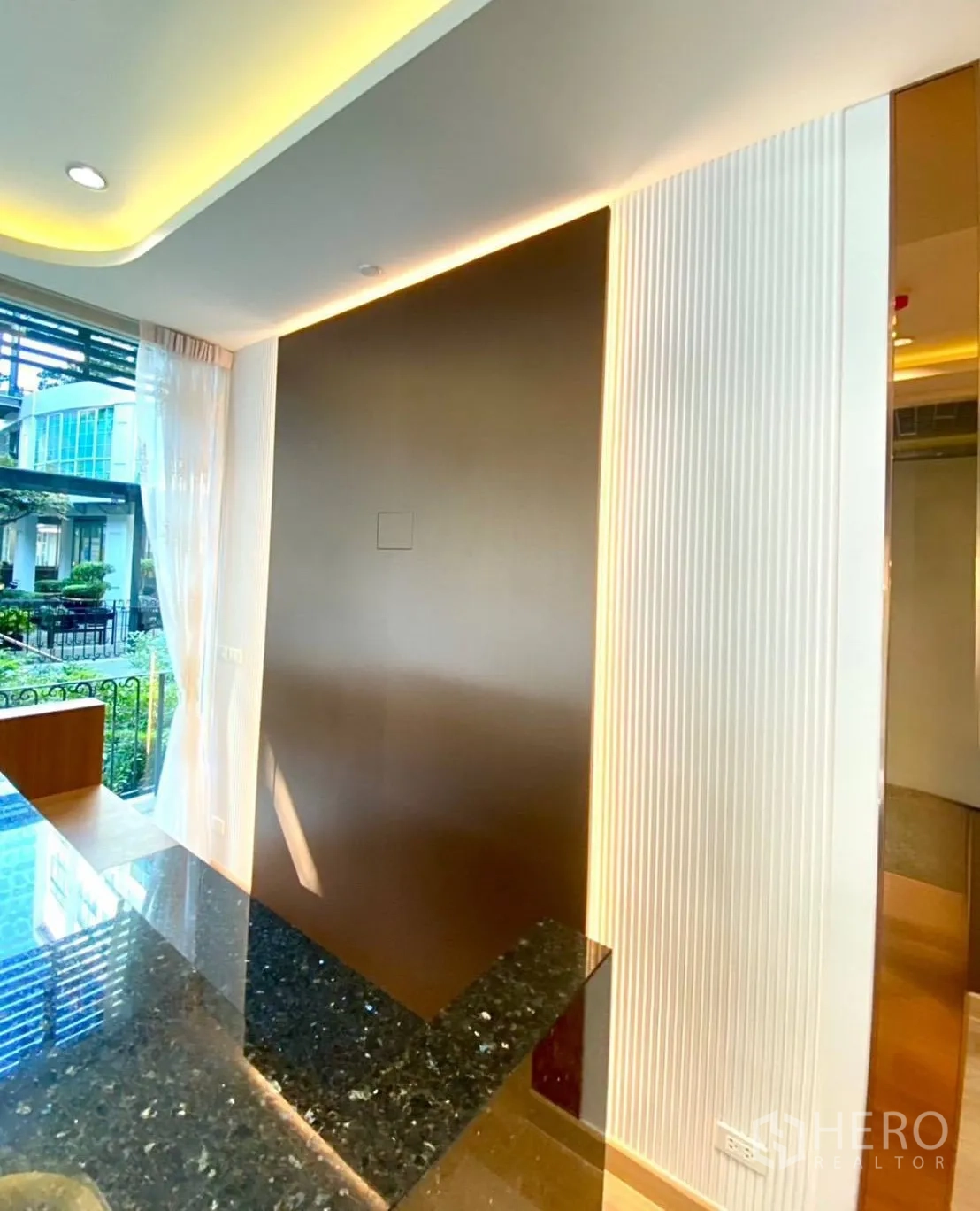 Office Space for rent - Feature wall with warm accent lighting beside glossy black stone counter.