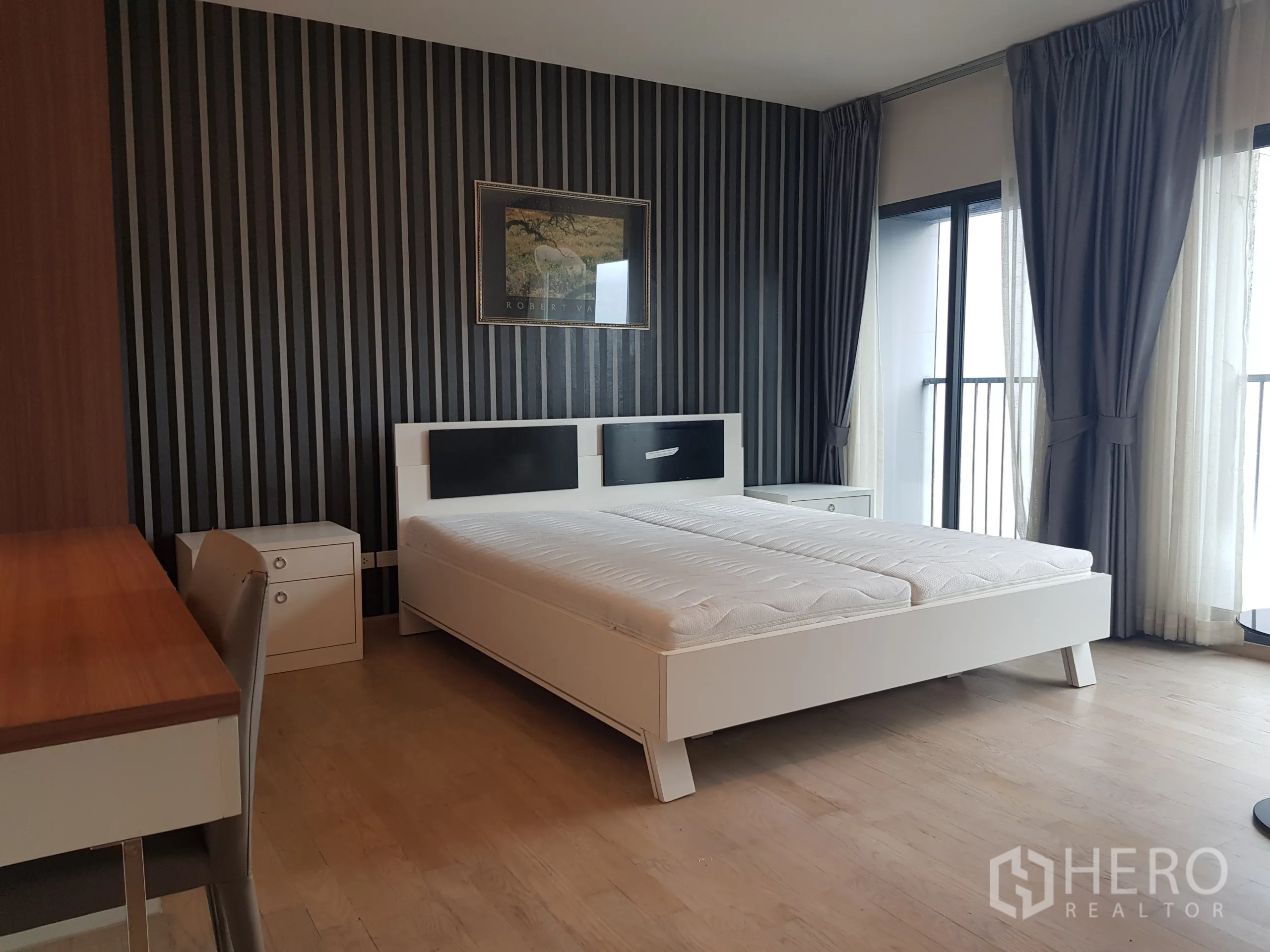 Condominium for rent in Khlong Toei, Bangkok - Bedroom with twin beds combined as king, striped feature wall and balcony doors.
