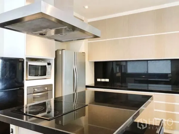 คอนโด ให้เช่าในKhlong Toei, Bangkok - ครัวสไตล์โมเดิร์น เคาน์เตอร์ท็อปหินสีดำ เตาไฟฟ้า ฮู้ดสแตนเลส พร้อมตู้เย็นประตูคู่