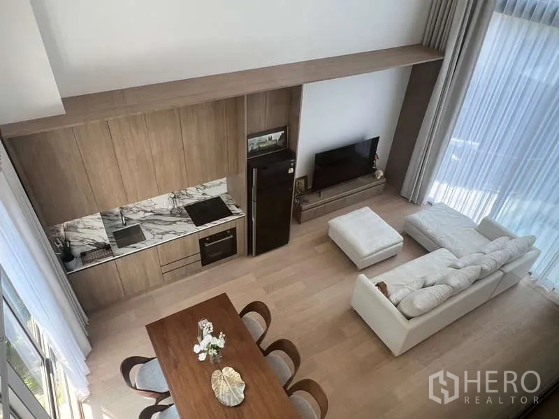 ทาวน์เฮาส์ ให้เช่าในPhra Khanong, Bangkok - มุมมองโถงรับแขกเพดานสูงพร้อมครัวแพนทรี่ โต๊ะทานข้าว และชุดโซฟา