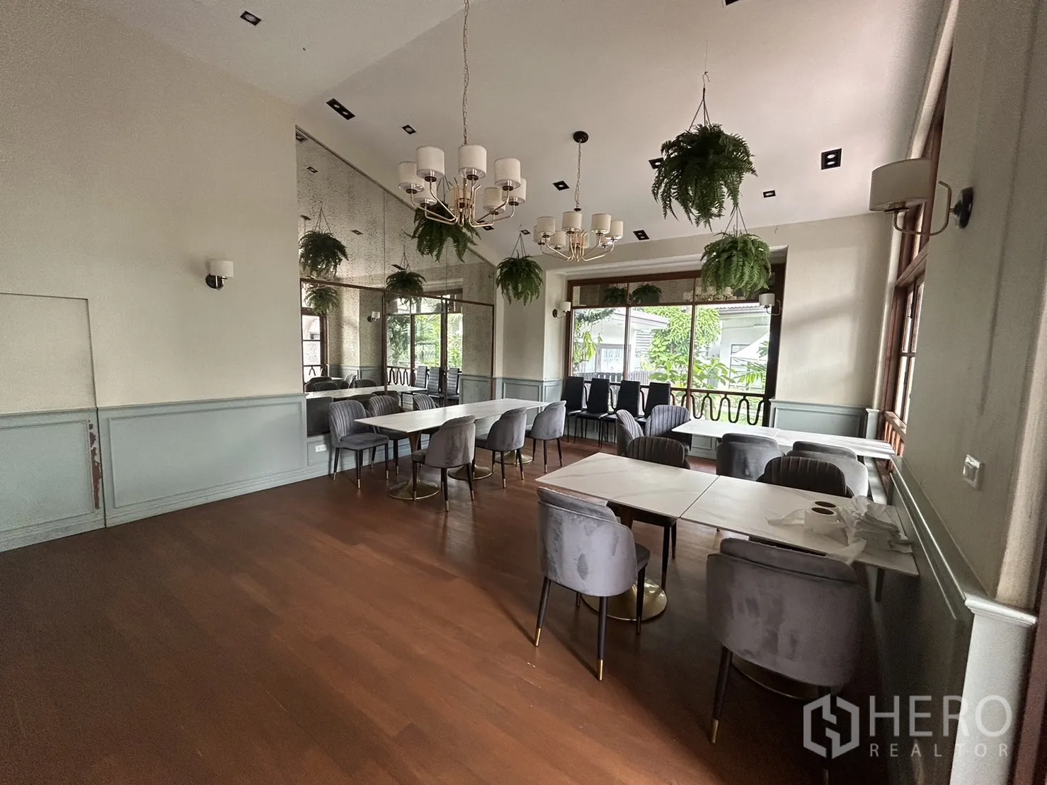 พื้นที่ขายปลีก ให้เช่าในBangkok - พื้นที่นั่งกว้างพร้อมกระจกเงา โคมระย้า พื้นไม้ และวิวต้นไม้จากหน้าต่างบานกว้าง