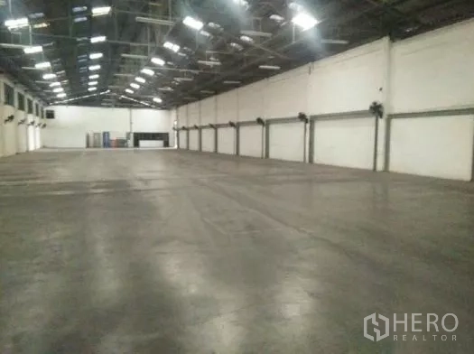 货栈 出租在Khlong Luang, Pathum Thani - 仓库内部，高钢结构屋顶、抛光混凝土地面与墙面排风扇。