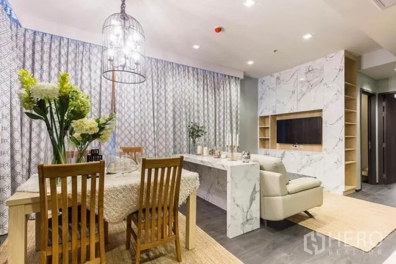 คอนโด ให้เช่าหรือขายในWatthana, Bangkok - ผนังหินอ่อนบิลต์อินทีวีและเคาน์เตอร์ ต่อเนื่องกับโต๊ะอาหารจัดแจกันดอกไม้