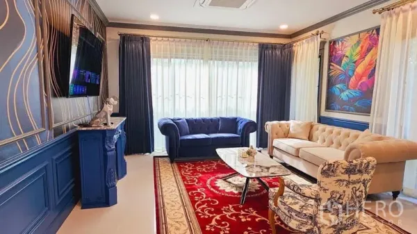 Detached House for rent or sale in Saphan Sung, Bangkok - Elegant lounge with blue and cream sofas, red rug, marble coffee table and large windows.