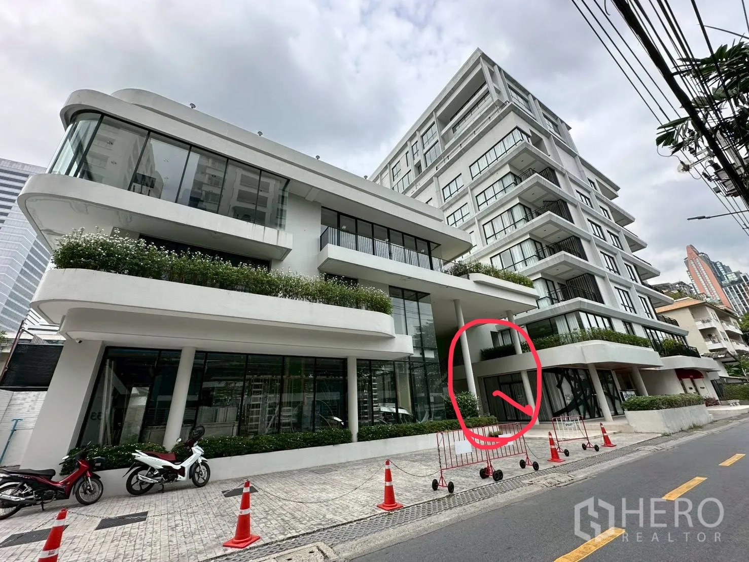 Retail Space for rent in Sathon, Bangkok - Modern multi-storey building with curved white facade, floor-to-ceiling glass, planters, and street-facing frontage.