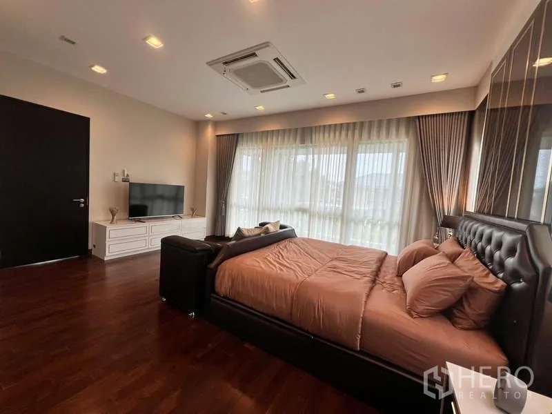 บ้าน ให้เช่าหรือขายในLat Krabang, Bangkok - ห้องมาสเตอร์กว้าง พร้อมชั้นวางทีวี หน้าต่างบานใหญ่ และผ้าม่านโปร่ง