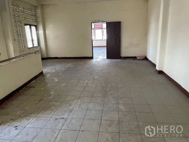 Shophouse for rent in Watthana, Bangkok - Large tiled level with ventilation blocks on the side wall and doorway to a front room.