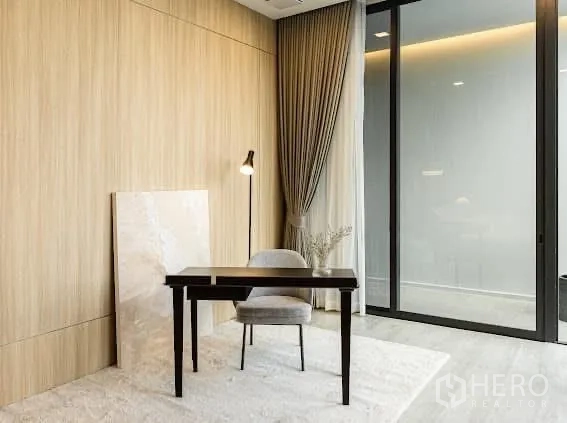 独栋房屋 for rent or sale in Saphan Sung, Bangkok - 极简书房，设书桌、座椅、落地灯与推拉玻璃门。