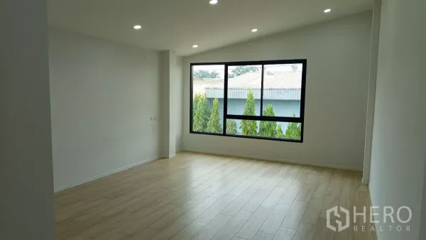 货栈 出租或出售在Lam Luk Ka, Pathum Thani - 二楼办公室木纹地面，宽窗望向绿化景观。