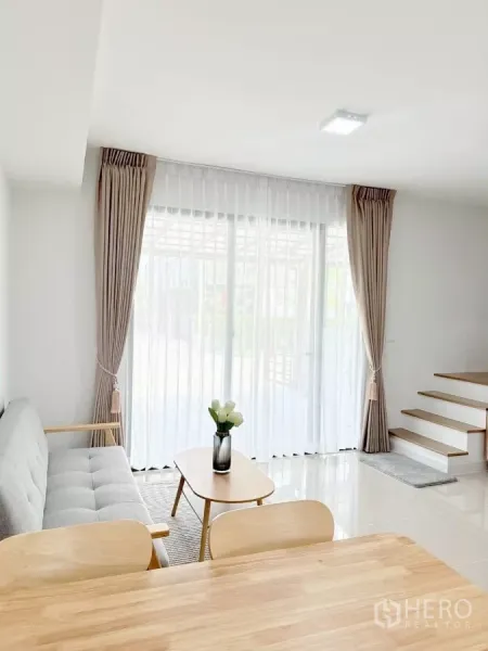 ทาวน์เฮาส์ ให้เช่าในBang Phli, Samut Prakan - ห้องนั่งเล่นมีประตูกระจกบานเลื่อน ผ้าม่านโปร่ง และบันได