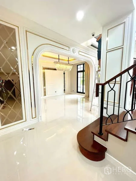 Detached House for sale in Thawi Watthana, Bangkok - Bright living space with glossy floors and curved wooden stair with iron balustrade