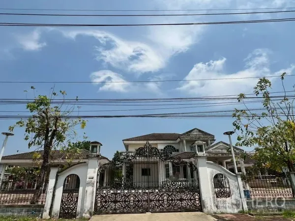 独立式住宅 出租在Prawet, Bangkok - 街景正门，锻铁花纹大门与白色围墙的独栋别墅
