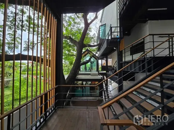 带办公室的家 出租在Chatuchak, Bangkok - 高架连廊靠近大树，设竖向百叶与玻璃亭。