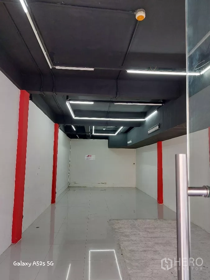 พื้นที่ขายปลีก ให้เช่าในKhlong Toei, Bangkok - ภายในร้านแบบโถงโล่ง พื้นกระเบื้องเงา ผนังขาว คานสีแดง เพดานสีดำไฟเส้น LED