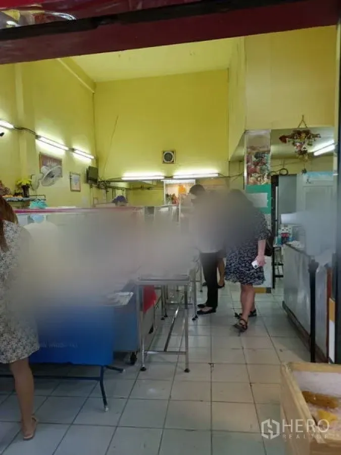 店屋 出租在Phaya Thai, Bangkok - 店屋底层室内，高挑天花与黄色墙面，瓷砖地面与不锈钢操作台，适合餐饮或零售布局