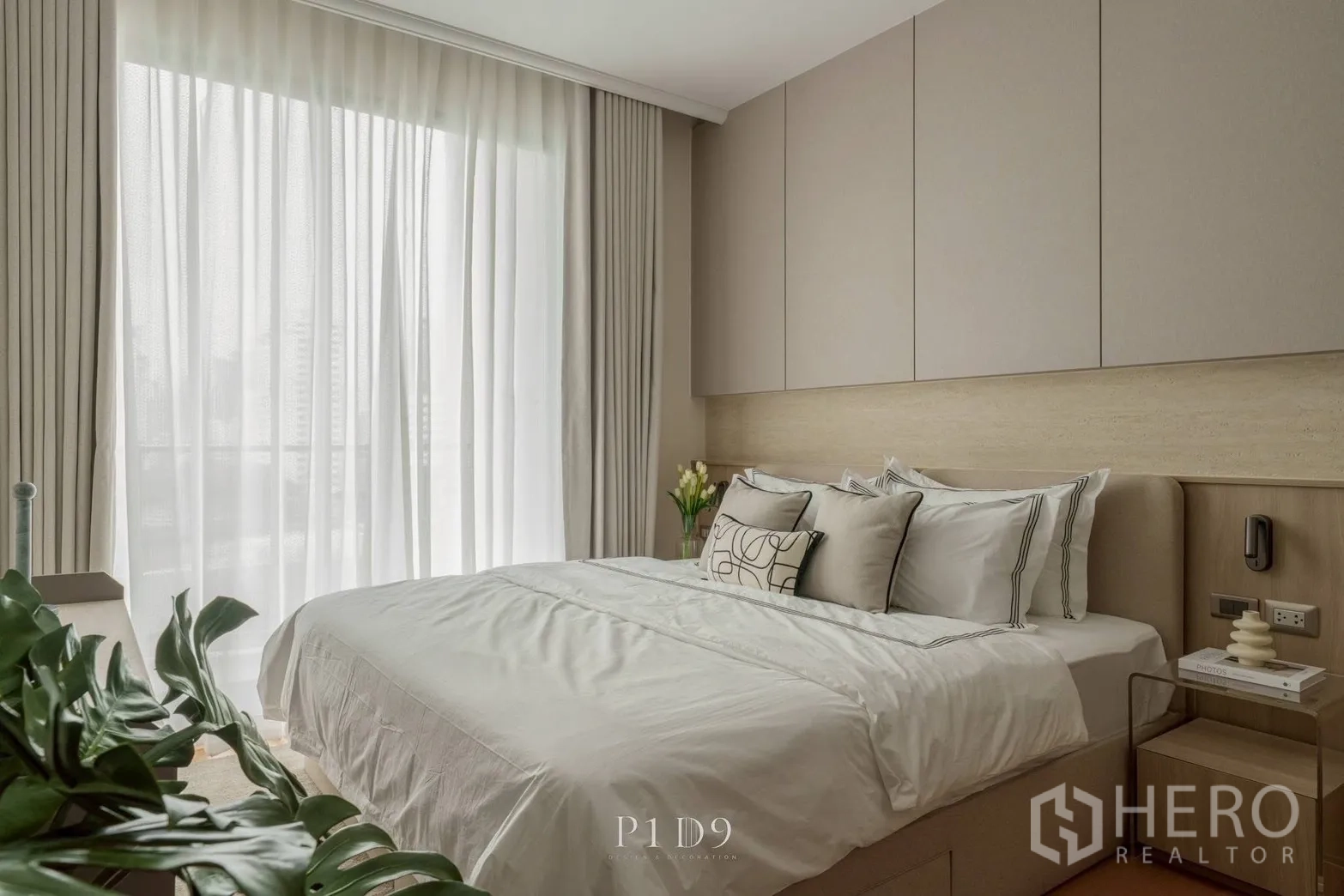 Condominium for rent in Watthana, Bangkok - Light-filled bedroom with a neatly dressed bed and neutral decor.