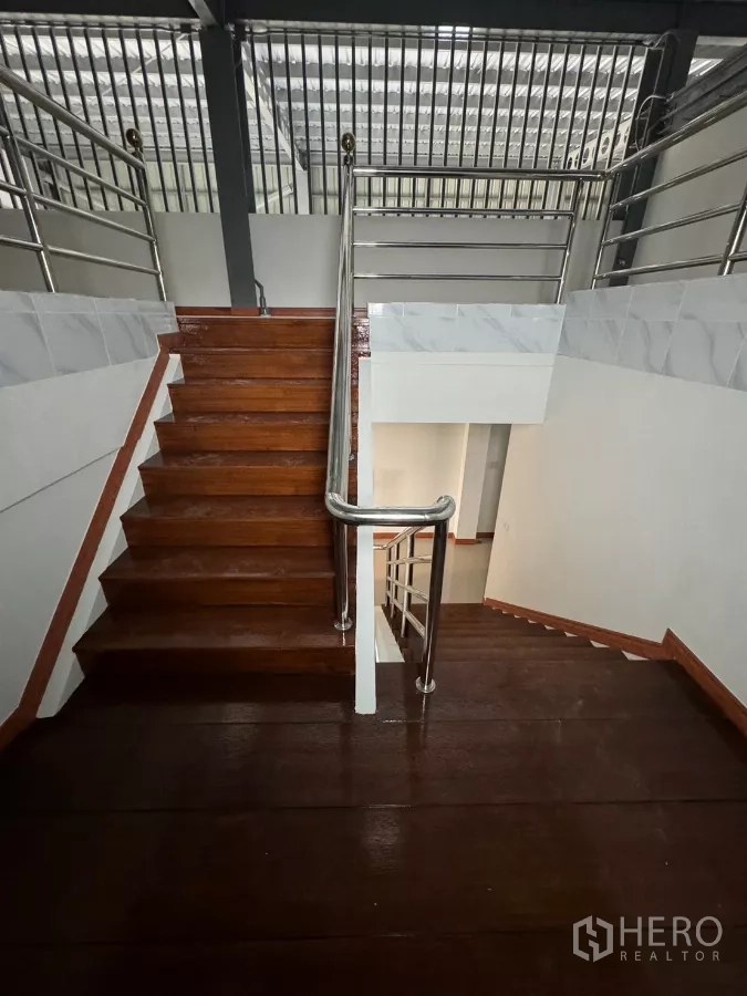 Warehouse for rent in Bang Khun Thian, Bangkok - Solid wooden staircase leading to the mezzanine and office levels.