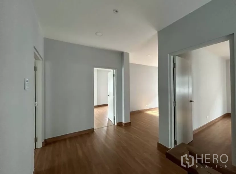 独立式住宅 出租在Bang Phli, Samut Prakan - 楼梯平台区，通往多间卧室，木地板。